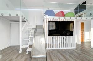 a room with a crib with a tv and a staircase at Dom & House – Old Town Waterlane in Gdańsk