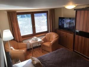 a hotel room with a bed and chairs and a television at Apartment pod Lysou in Frýdlant nad Ostravicí