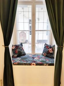 a window seat with pillows in front of a window at Danube Elegance Apartment in Budapest