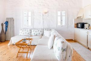 a white living room with a couch and a table at Antiparos Vibes in Agios Georgios