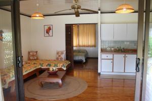 a living room with a couch and a kitchen at MOOREA - Fare Taina Dream in Hauru