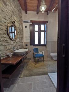 a bathroom with a tub and a sink and a chair at L'Antica Dimora - Suites & Apartments in Màndas +39 photos