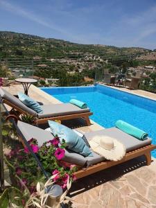 a pool with two lounge chairs and a swimming pool at Kalypso View Apartments in Letimbou