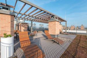 a patio with chairs and a pergola on a building at Blue Mandarin Garden Gates in Gdańsk
