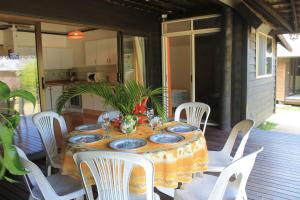 een tafel en stoelen op een veranda met een tafel en borden bij MOOREA - Fare Taina Dream in Hauru