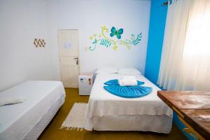 a bedroom with two beds and a butterfly on the wall at Pousada Sunset Boipeba in Ilha de Boipeba