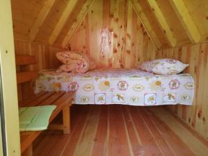 Camp Zabojsko lake في مويكوفاتش: سرير في كابينة ذات أرضية خشبية