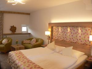 een hotelkamer met een bed en twee stoelen bij Hotel Chrysantihof in Bad Birnbach