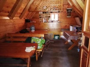 Camp Zabojsko lake في مويكوفاتش: غرفة مع طاولات وكراسي خشبية في كابينة