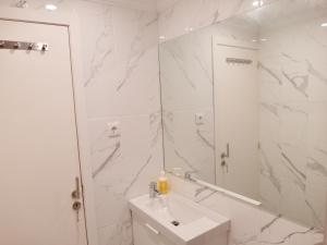 ein weißes Badezimmer mit einem Waschbecken und einem Spiegel in der Unterkunft BairroSweethome in Lissabon