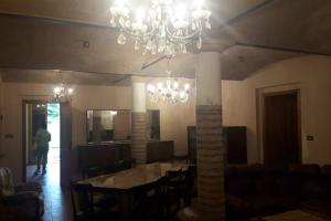 una sala da pranzo con tavolo e lampadario pendente di Grande Casa in Via Zappellazzo Gattatico (RE) a Campegine