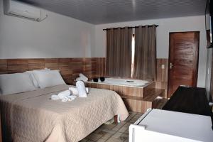 Habitación de hotel con cama y bañera en Pousada Estrela Guia en Pirenópolis