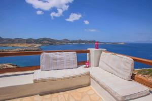 two chairs on a balcony with a view of the ocean at Antiparos Vibes in Agios Georgios