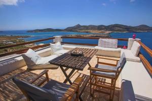 a patio with a table and chairs and the ocean at Antiparos Vibes in Agios Georgios