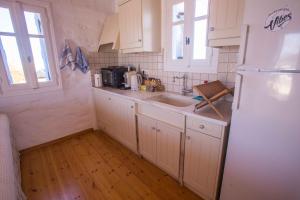 a kitchen with a white refrigerator and a sink at Antiparos Vibes in Agios Georgios