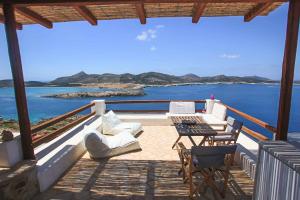 a balcony with a table and chairs and the ocean at Antiparos Vibes in Agios Georgios