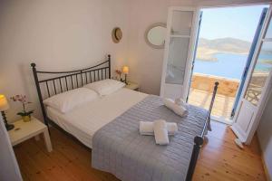 a bedroom with a bed with a view of the ocean at Antiparos Vibes in Agios Georgios