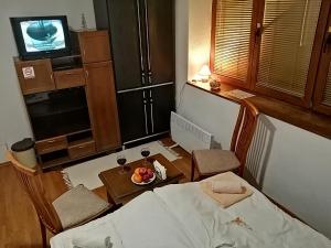 Cette chambre comprend un lit, une table et une télévision. dans l'établissement 'By the Lake' Apartments, à Ohrid