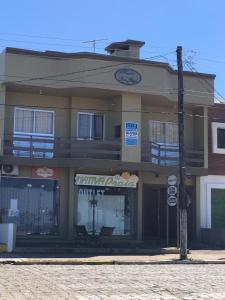 a building on a street corner with a building with a sign at Lindo Apto Frente Praia - Cond Dom Felippe in São Lourenço do Sul