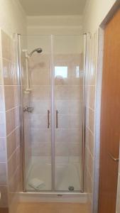una ducha con puerta de cristal en un baño en Cosy villa near the beach, en Zadar