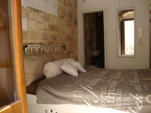 una camera con un letto e un muro in pietra di Le Nicchie a Bari