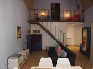 班約萊斯的住宿－Plaça Major 17 2n 2a Apartament al centre de Banyoles，带沙发和楼梯的客厅