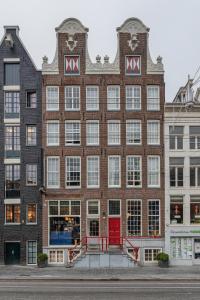a large brick building with a red door at Hotel des Arts in Amsterdam