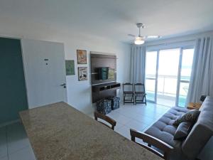 un salon avec un canapé et une table dans l'établissement PRAIA DO FORTE - PÉ NA AREIA - 6 hóspedes, à Cabo Frio