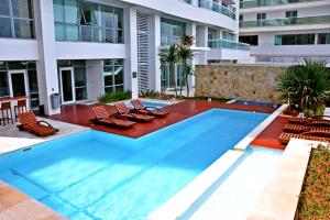 une grande piscine avec des chaises et un bâtiment dans l'établissement PRAIA DO FORTE - PÉ NA AREIA - 6 hóspedes, à Cabo Frio