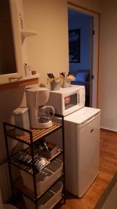 a small kitchen with a microwave and a refrigerator at Majoitus Hermanni in Teuva