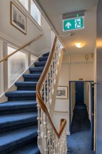 un escalier dans un bâtiment avec un panneau sur le mur dans l'établissement Hotel des Arts, à Amsterdam