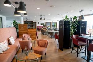 a restaurant with a couch and chairs and tables at Hotel Campo in Renningen