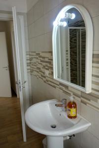 een badkamer met een witte wastafel en een spiegel bij casa vacanze, via delle margherite 3 in Montecorvino Pugliano