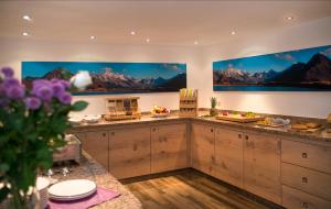 una cocina con armarios de madera y pinturas en las paredes. en Landhaus Lexner, en Tux