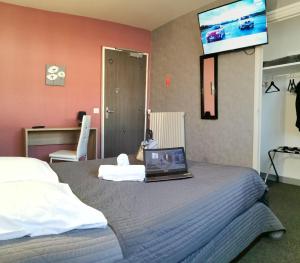 a bedroom with a bed with a laptop on it at La Vieille Ferme in Les Ancizes-Comps