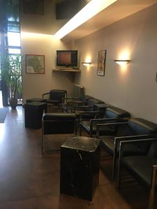 a waiting room with chairs and a flat screen tv at Kyriad Rodez in Rodez