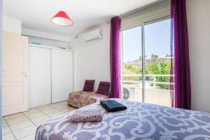 a bedroom with a bed and a large window at T4 Duplex vue mer 150m de la plage avec Bienvenue Location in Saint-Gilles les Bains