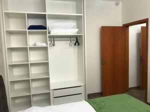 een witte kast met planken en een bed in een kamer bij Casa - Próximo a UFSC e CENTRO - 5 KM in Florianópolis