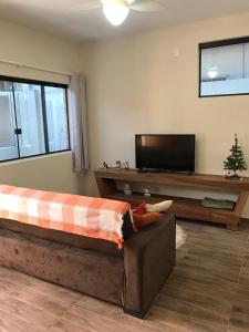 a living room with a couch and a flat screen tv at Casa - Próximo a UFSC e CENTRO - 5 KM in Florianópolis