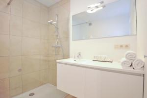 un bagno bianco con doccia e lavandino di Residentie Rivella a Koksijde Altre 11 foto