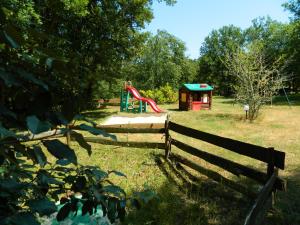 um parque infantil com um escorrega junto a uma cerca em le clos des dryades f em Vers