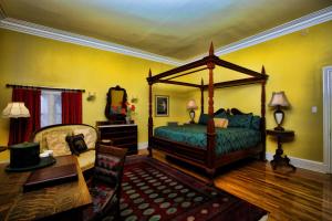 五月岬郡南方大厦住宿加早餐旅馆的一间带一张天蓬床的卧室,位于带桌子的房间内 更多5张照片