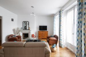 Una sala de estar con un sofá y una chimenea. en Le Hauban by Cocoonr, en Saint-Malo 8 fotos más