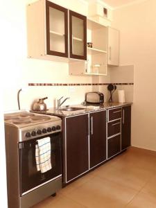 una cocina con estufa y fregadero en RS Las Grutas, en Las Grutas