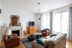 Una sala de estar con un sofá y una chimenea. en Le Hauban by Cocoonr, en Saint-Malo