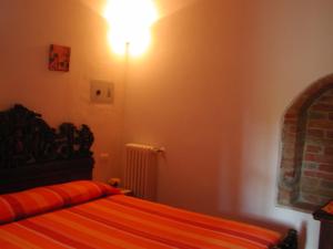 a bedroom with a bed and a light on the wall at Casale Il Colombaio Di Toiano in Sovicille