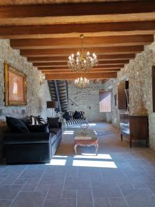 a living room with a couch and a chandelier at L'Antica Dimora - Suites & Apartments in Màndas