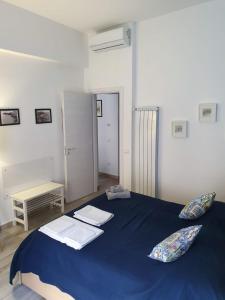 a bedroom with a blue bed with pillows on it at Casa del Moro in Cefalù