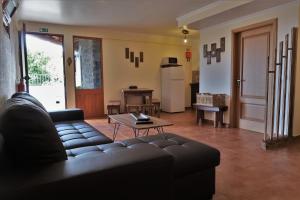 salon z czarną kanapą i stołem w obiekcie Casa do Vinho 5 "Vila Maria Quinta" w mieście Calheta