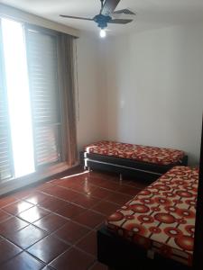 Zimmer mit 2 Betten und 2 Fenstern in der Unterkunft Apartamento na Praia in Guarujá